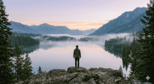 Hombre mirando al lago en el amanecer